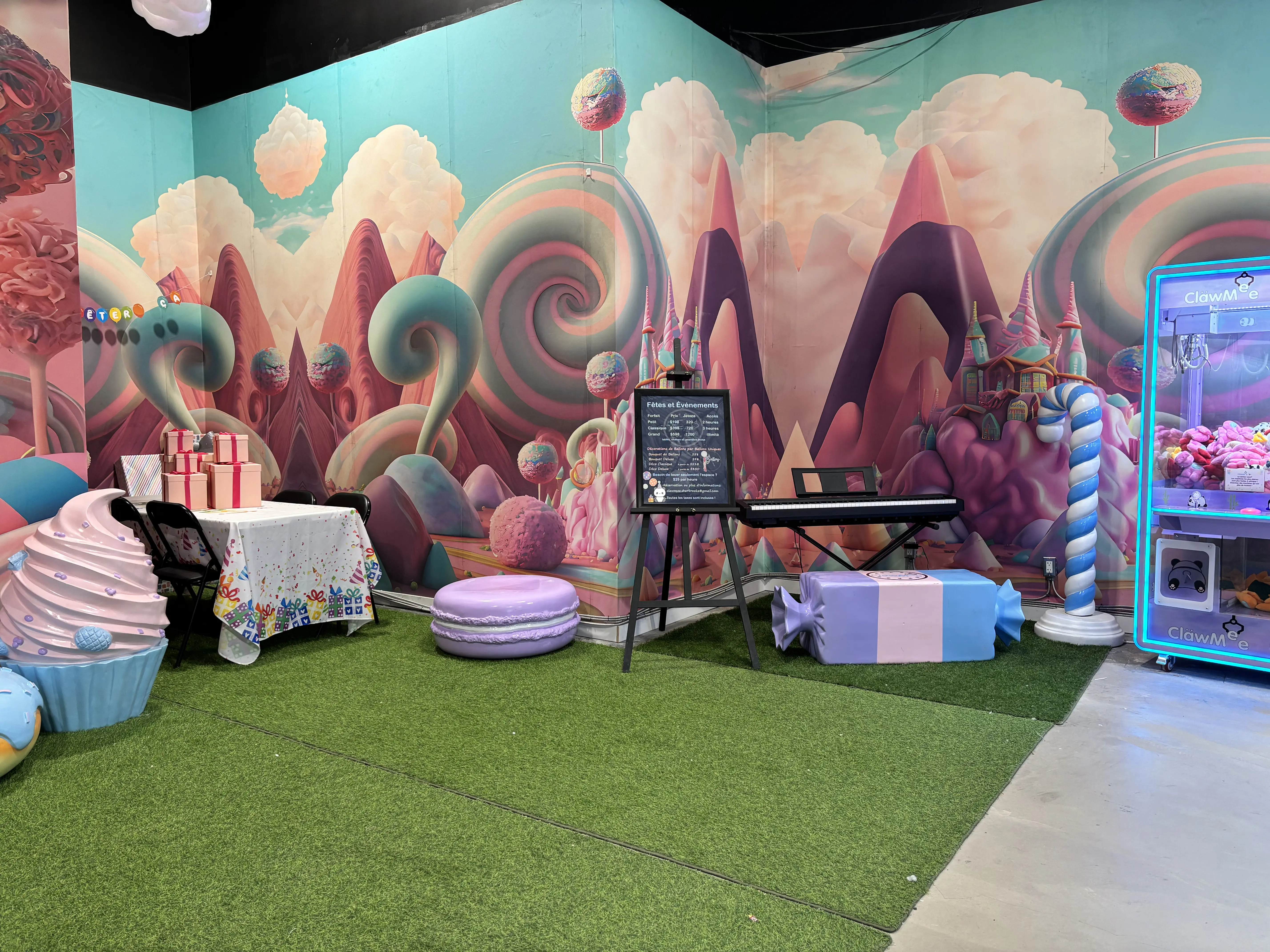 Candyland party room with a claw machine, candy seats and a large colourful mural