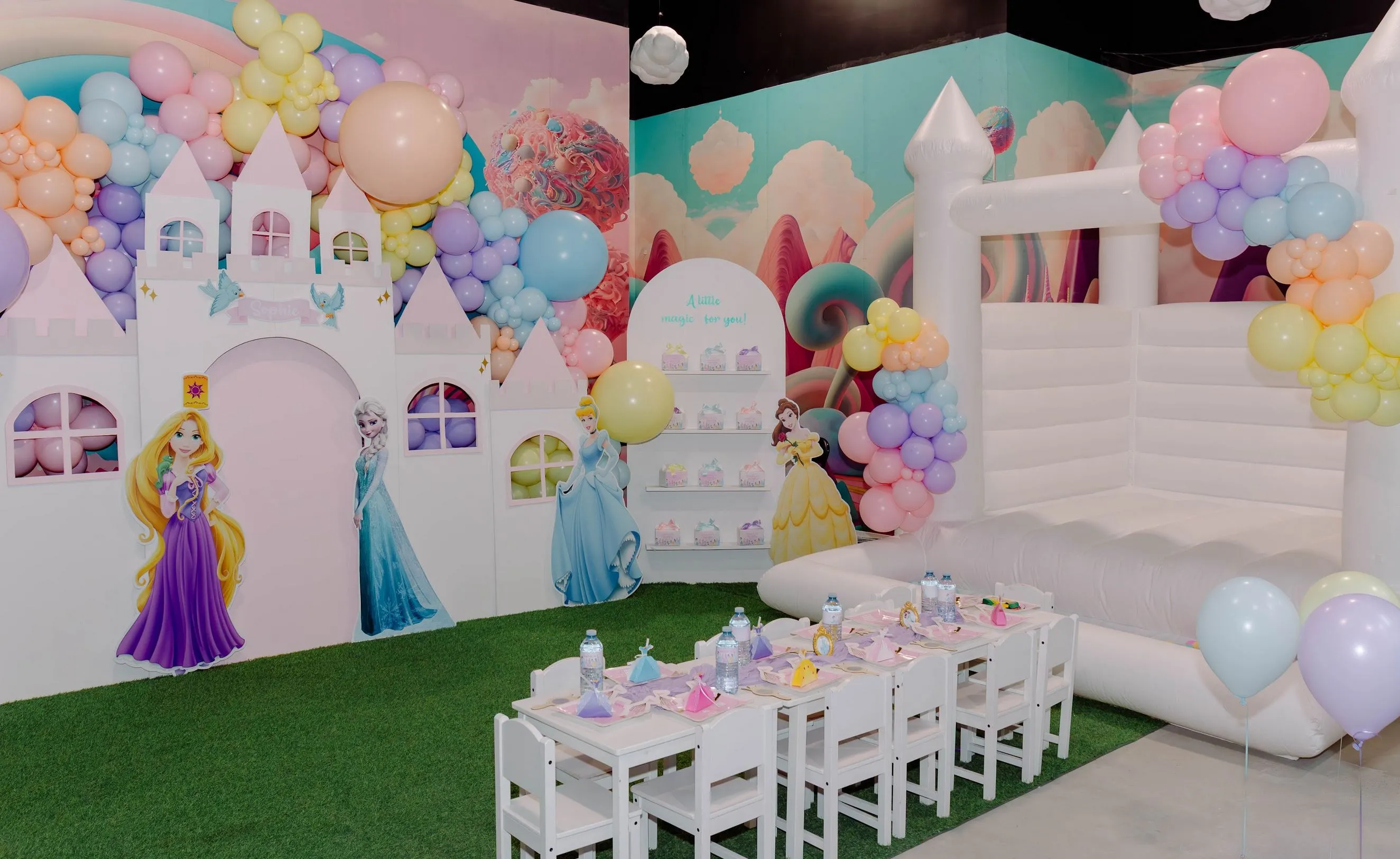 Princess birthday party setup: castle backdrop, pastel balloon arch and bounce house at ClawMee Sherbrooke