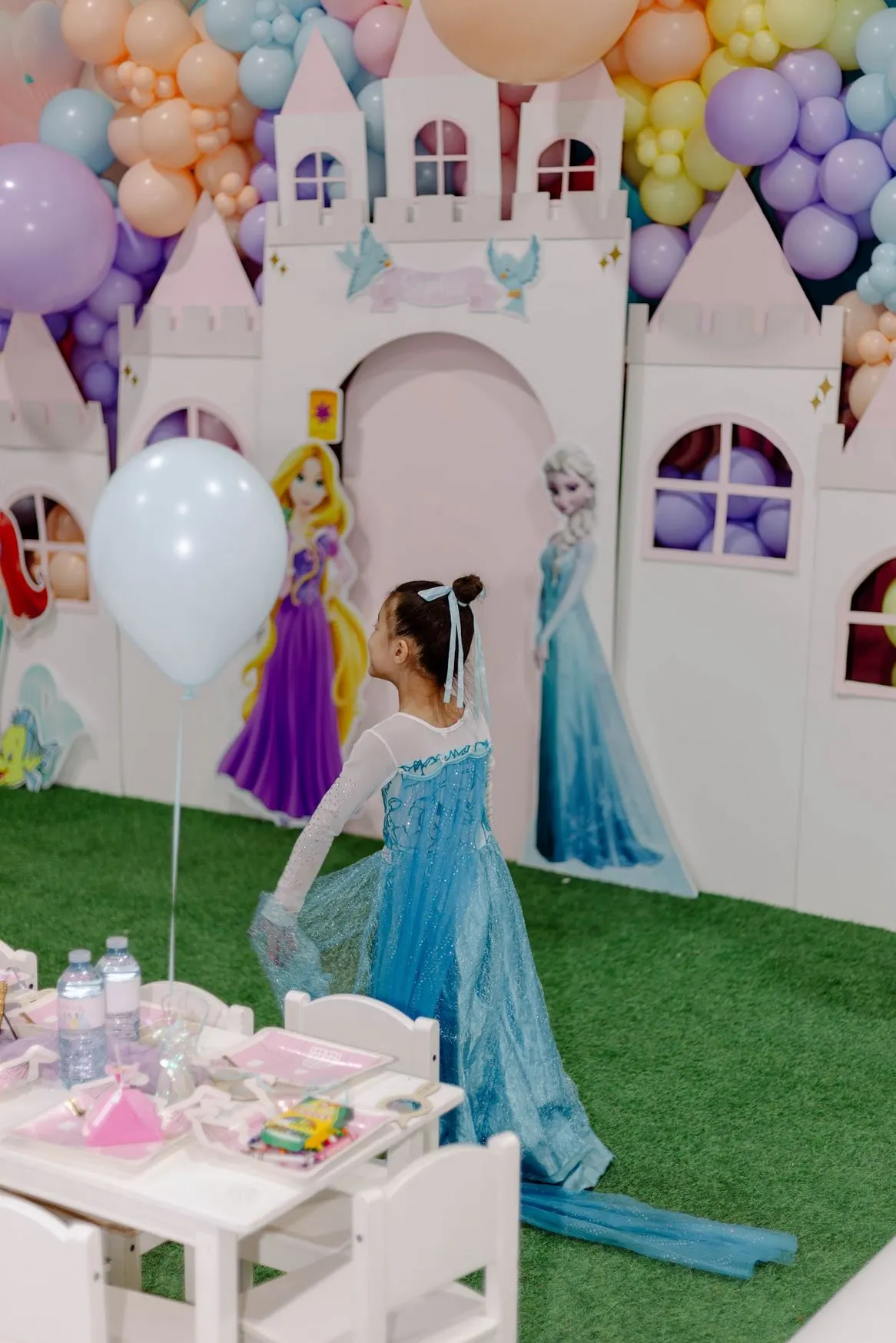 Child in a princess dress in front of the decorated party castle at ClawMee Sherbrooke