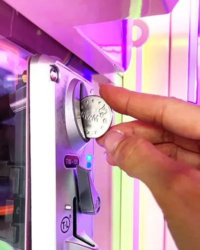 Token going into a ClawMee claw machine